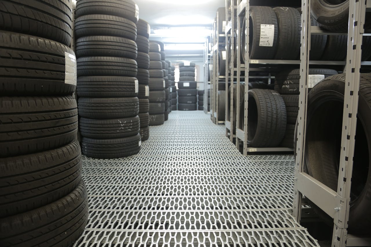 Rows of stacked tires in an indoor industrial warehouse for storage.